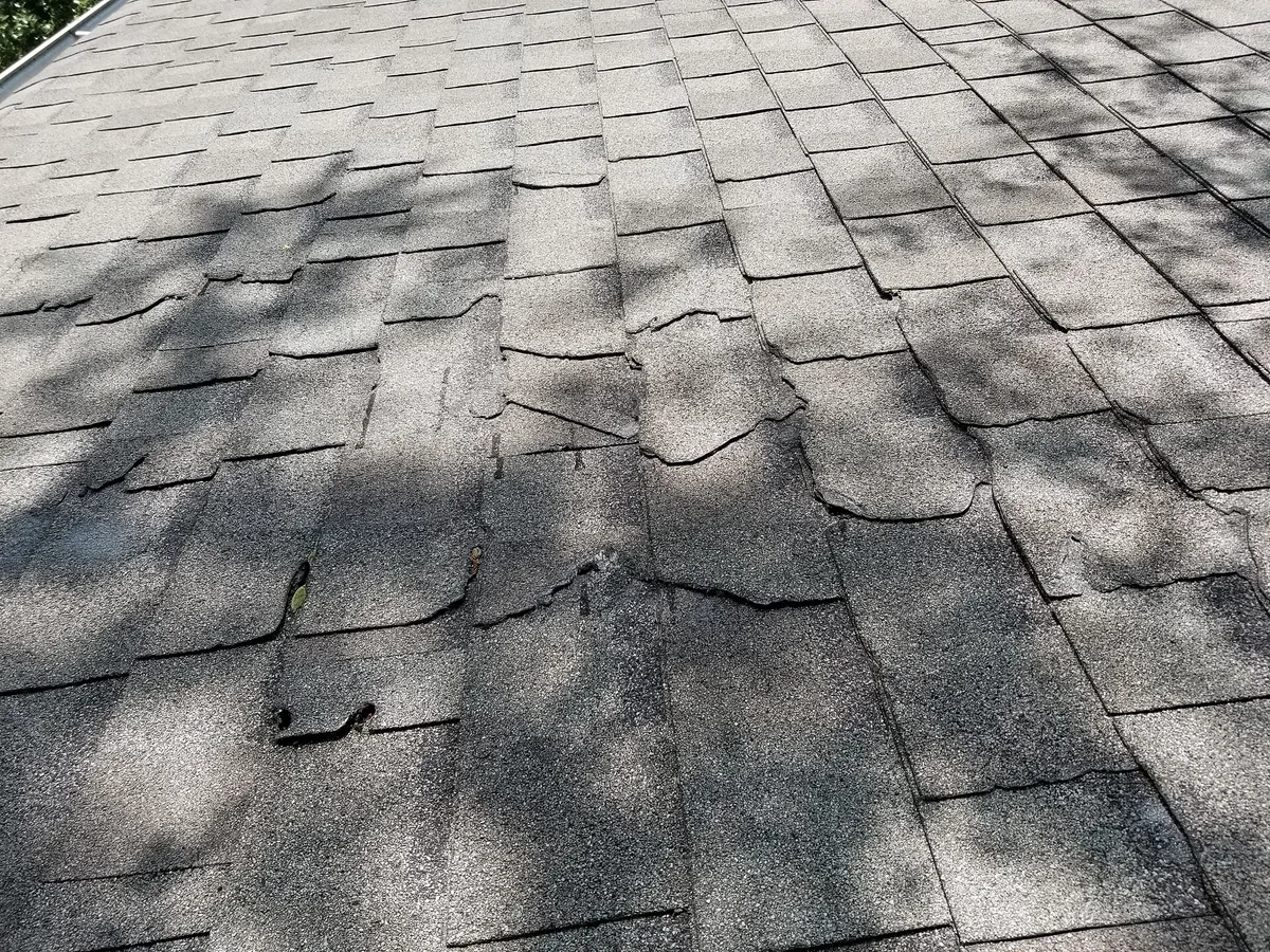 Storm-damaged asphalt shingles in need of emergency repair