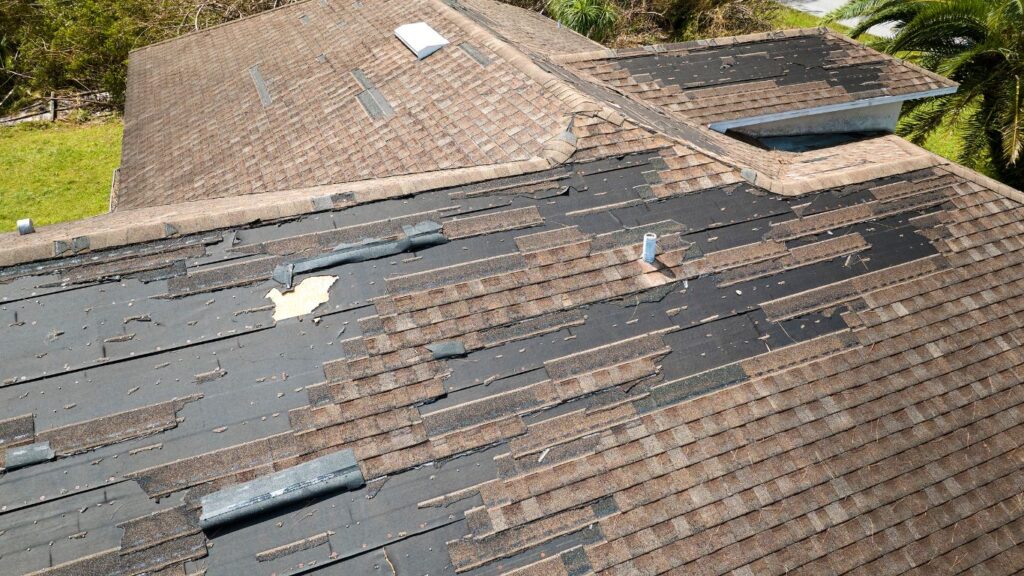 An aerial view of a roof with damaged shingles suggests it may be time for a roof replacement.